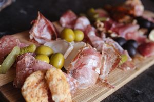 Detailansicht von Schinken, Salami, Oliven und Gurken.