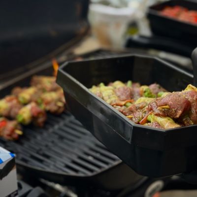 Rohe Grillspieße in einer Schale und ein Grill